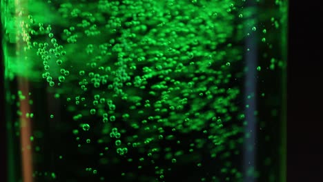 bubbles rising in a green fizzy drink