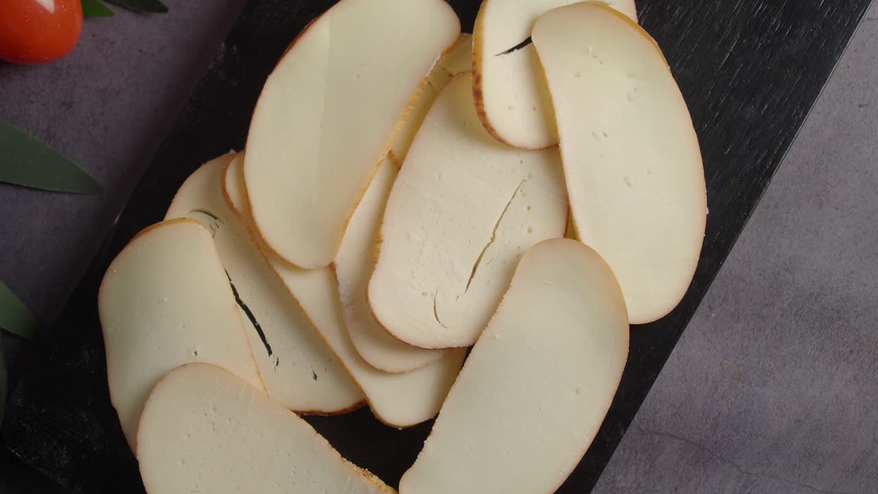 Fette di formaggio con pomodorini e avocado su un tagliere
