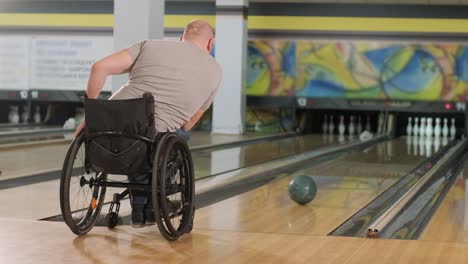 dos jóvenes discapacitados en sillas de ruedas jugando al bolos en el club