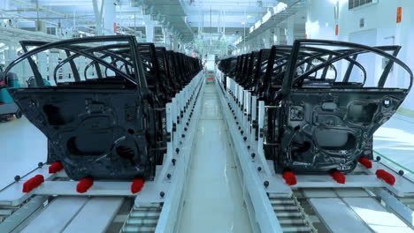 real shot automobile plant, modern production of cars, transportation of ready car doors on the manufacture line, robots at work