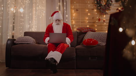 Allgemeiner-Plan-Der-Weihnachtsmann-Beantwortet-E-Mails,-Durchsucht-Die-Internetbank-Und-Arbeitet-An-Einem-Laptop