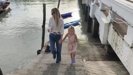 mother and daughter walking on pier