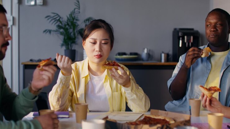 Coworkers Eating Pizza During a Meeting