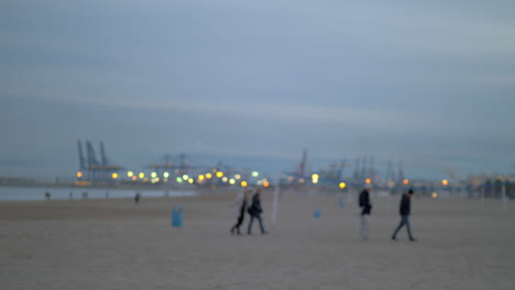 people walking on the beach on a cold day