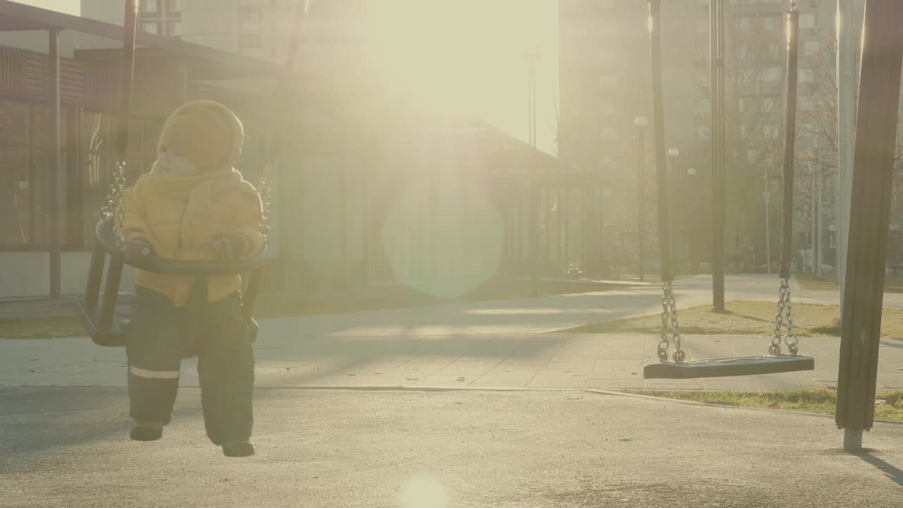 Child playing on a swing in a sunny park