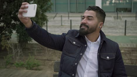 hombre barbudo teniendo una conversación de video al aire libre