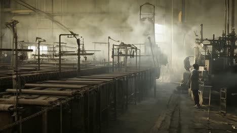 a man works in a dirty, old steel factory