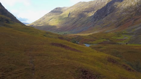 low flight down river valley to hiker in scottish highland mountains