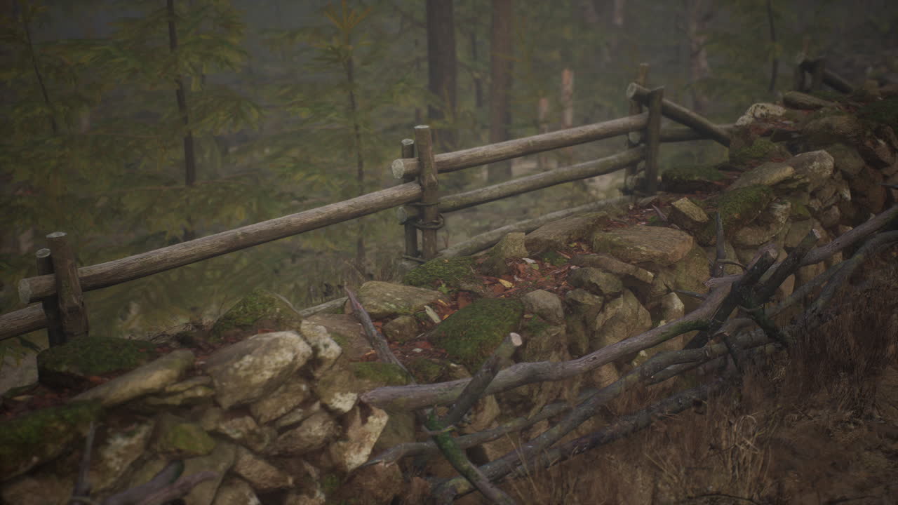 una vieja valla de madera con un campo de campo detrás de ella