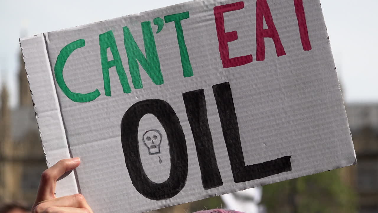 A handmade placard is held up that reads &ldquo;Can&rsquo;t Eat Oil&rdquo; on an Extinction Rebellion protest calling for an end to fossil fuel dependency