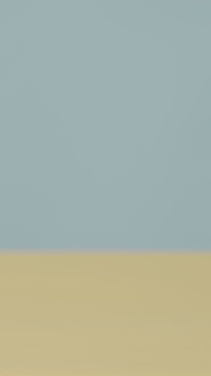 노란색 배경에 얼음과 함께 차가운 음료를 들고 손으로 수직 여름 휴가 개념