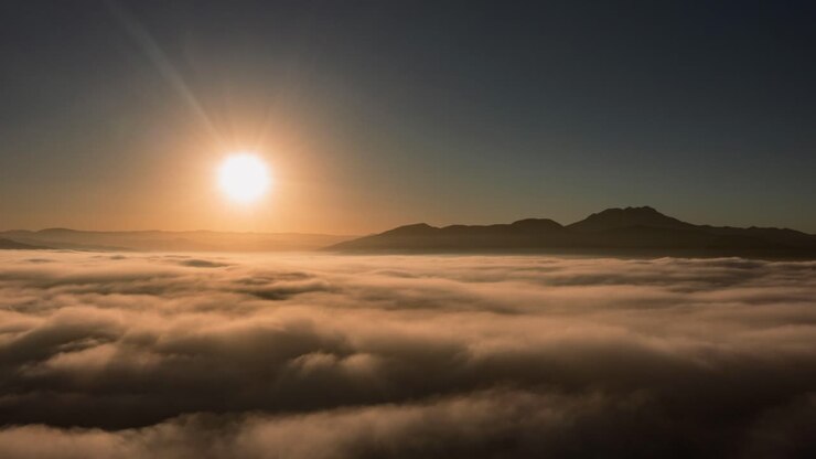 Time lapse del sole che filtra attraverso nuvole soffici, illuminando il cielo azzurro brillante.