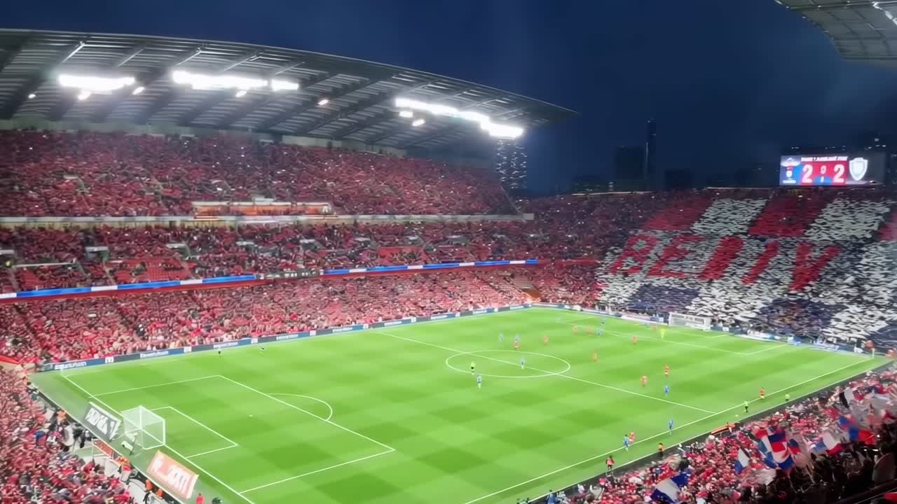 Video grandangolare che riprende uno stadio vivace di notte, mostrando uno spettacolo dinamico della folla