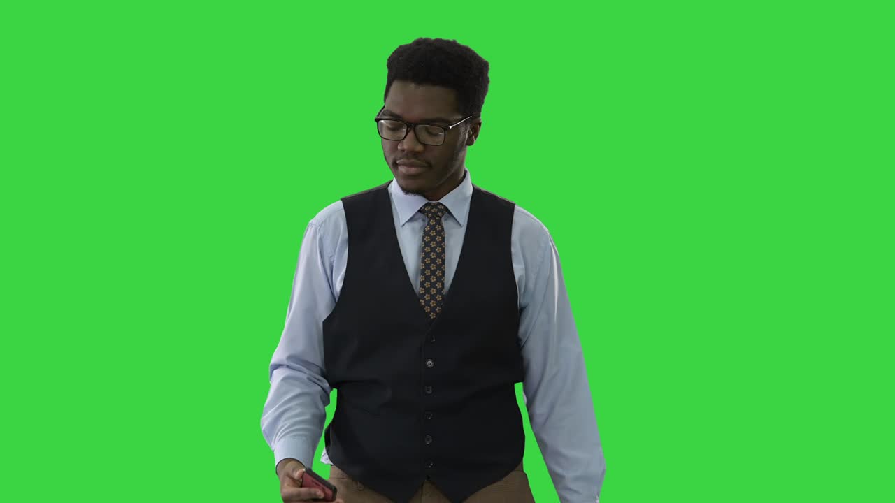 Empresário afro-americano tirando selfies com o celular enquanto caminha em uma tela verde, Chroma Key