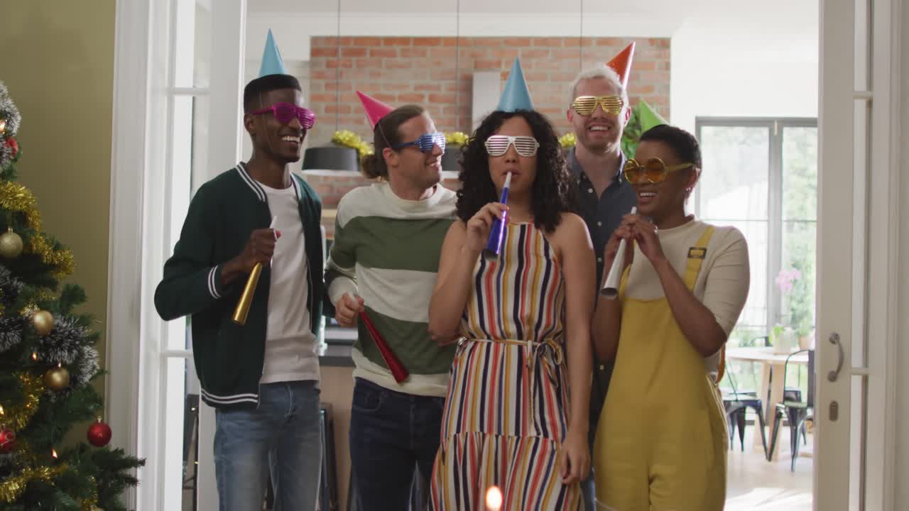 Gruppo felice di amici diversi con cappelli da festa che celebrano insieme