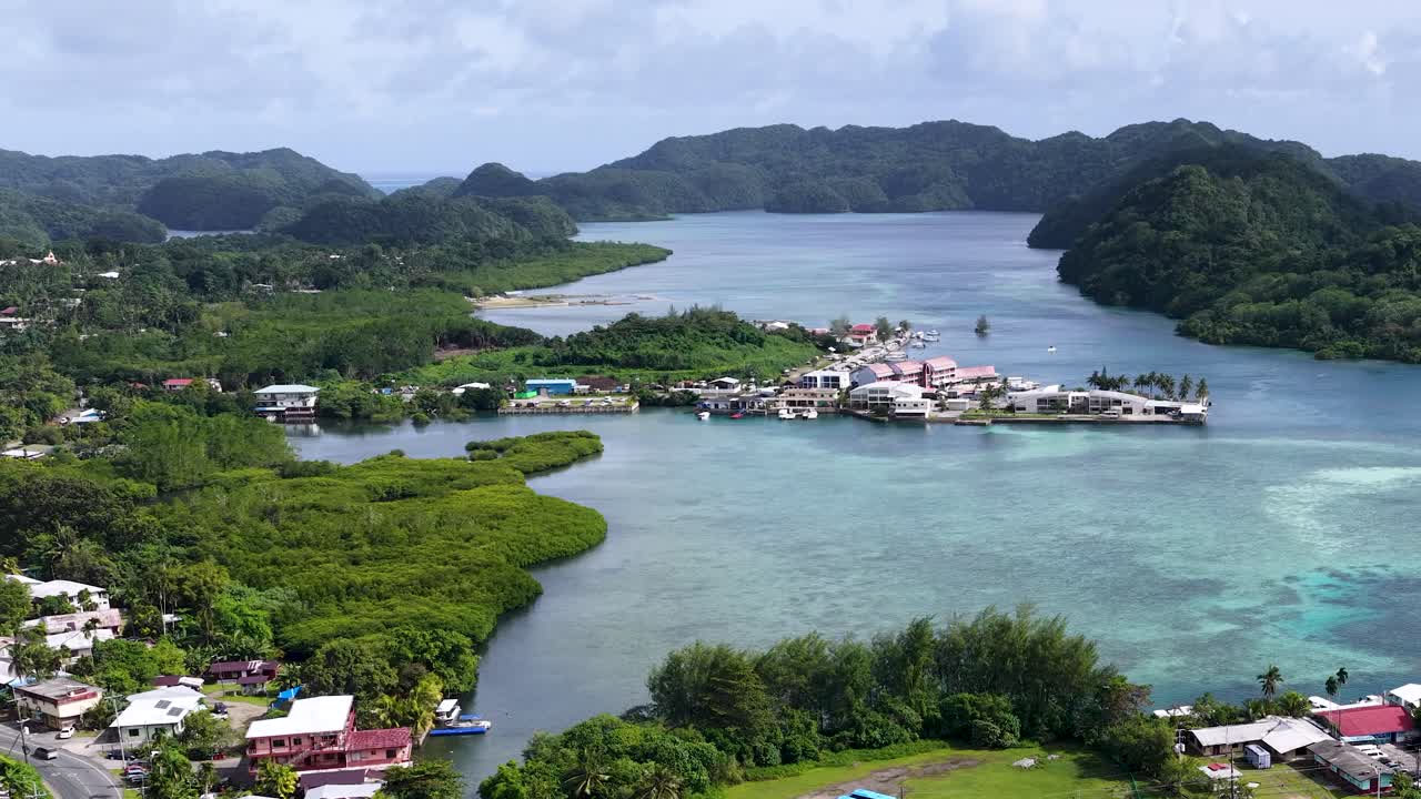 Ripresa aerea dall'alto di una cittadina costiera tropicale e di una baia turchese a Palau