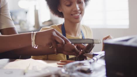 Busy-diverse-female-workers-shaping-ring-with-handcraft-tools-in-studio-in-slow-motion