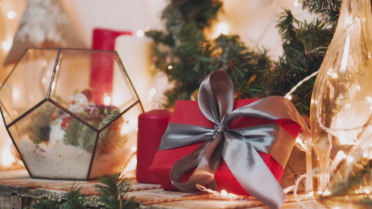 Christmas theme. Young woman puts the gifts under the Christmas tree. In the defocusing.