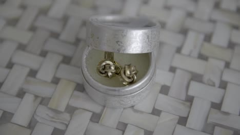 close-up shot of a pair of cufflinks in an elegant silver box, showcasing luxury and detail.