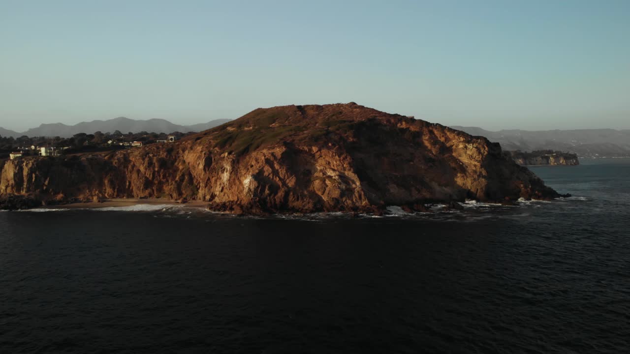 una toma aérea del hermoso acantilado point dume en malibu en una noche tranquila mientras las vibrantes puestas de sol