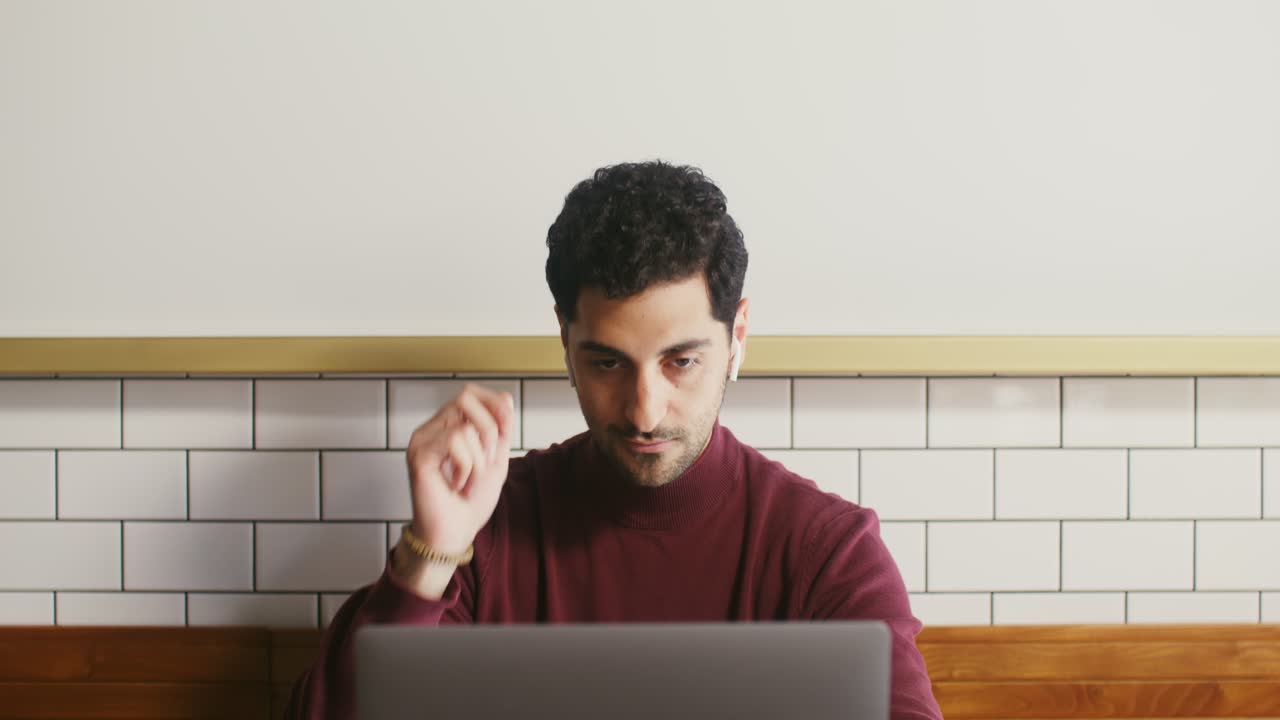 un hombre trabajando en una computadora portátil en un café