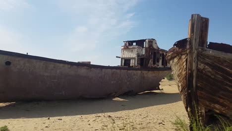 Abandoned-Ship-and-Wooden-Boat-in-Decay-in-Sand-of-Former-Aral-Lake,-Natural-Disaster-Site-in-Uzbekistan-and-Kazachstan
