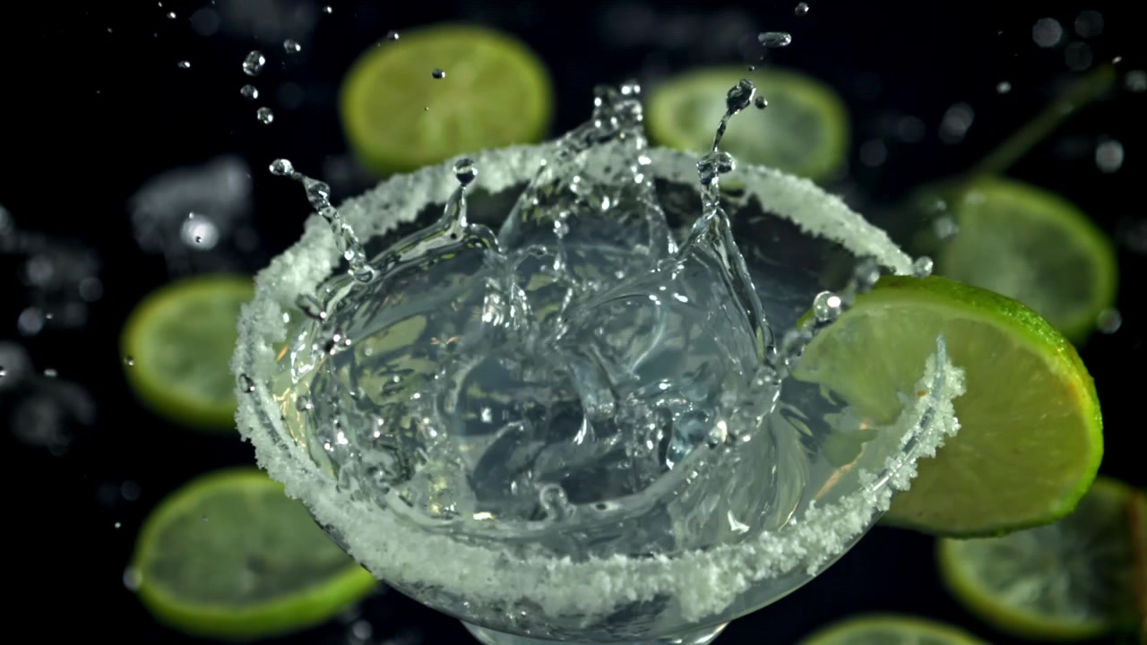 Cubetto di ghiaccio che si tuffa in un cocktail Margarita con lime e bordo di sale