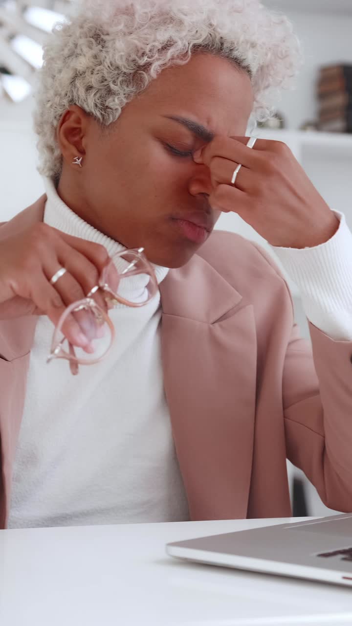 Businesswoman experiencing stress and headache at work