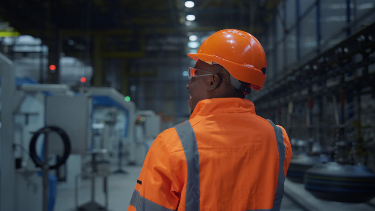 Supervisor walking huge modern energy production factory back view