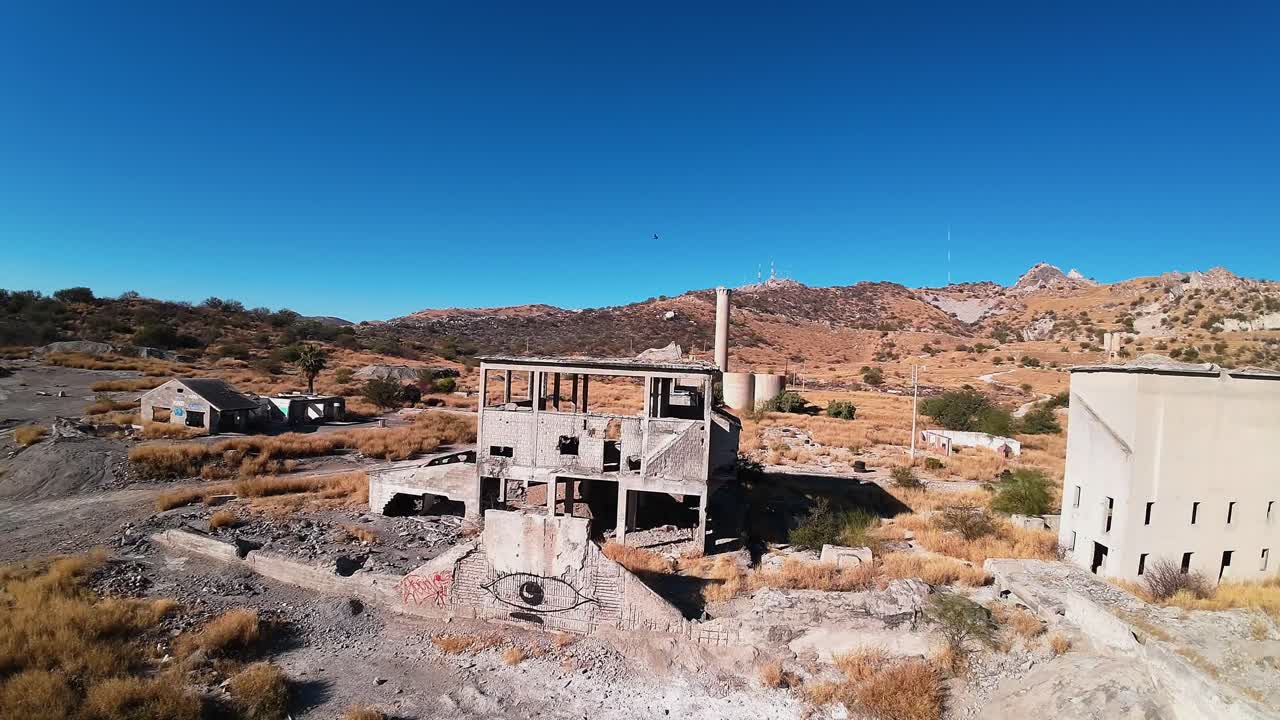 무인 항공기는 airsoft 스포츠가 실행되는 폐허가 된 건물과 군사 장비를 입은 여러 사람을 날아갑니다.