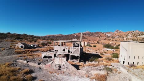 drone flies over ruined building where airsoft sport is practiced and several people dressed in military equipment