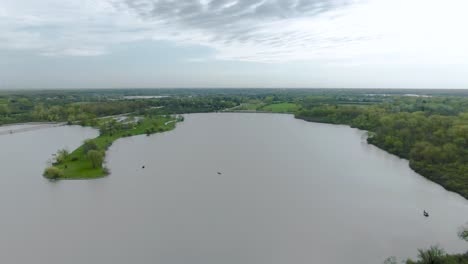 An-aerial-shot-over-a-lake-in-a-rural-area-with-fishing-boats-on-it