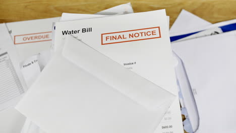 a pile of bills and letters with a final notice for a water bill during a cost of living crisis