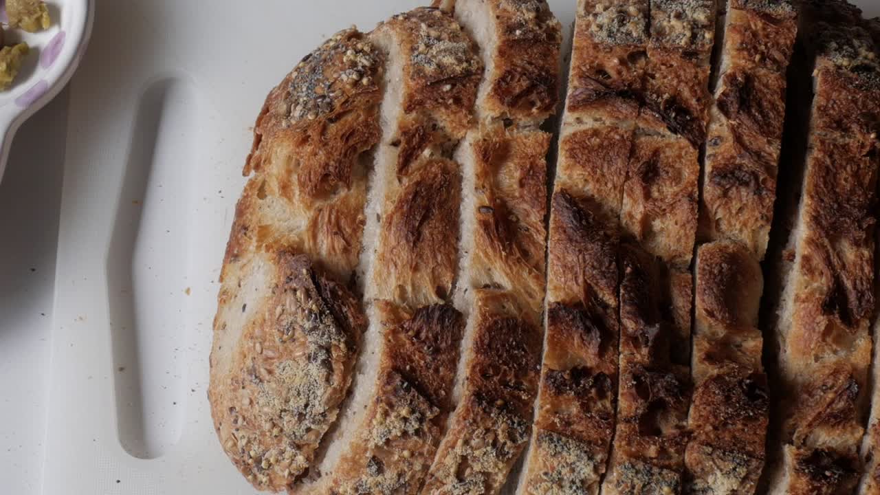Freshly sliced olive bread paired with olives and green pistachios for a snack