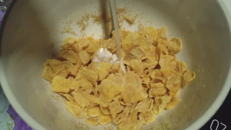 pouring milk ontop of cornflakes