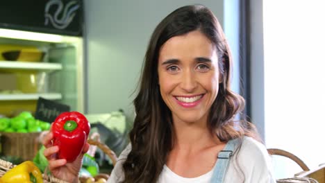 mujer seleccionando pimientos en la sección orgánica