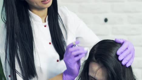 Platelet rich plasma injection procedure for hair growth stimulation in the beauty clinic. Beautician in medical coat and the patient of aesthetic medicine.