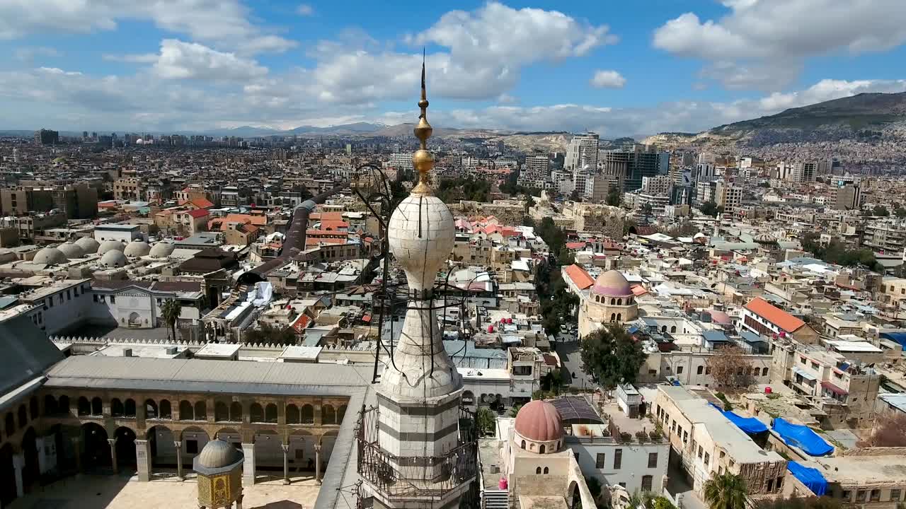 시리아의 우마야드 모스크의 미나을 둘러싼 아름다운 풍경. 드론이 미나 주변을 날아다니며 다마스쿠스 시가 배경입니다.