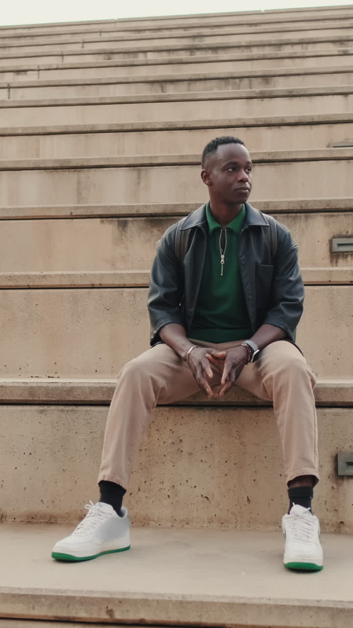 Young Black Man Sitting Thoughtfully on Concrete Steps Outdoors