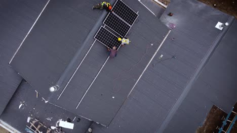 equipo de trabajadores en el techo de la casa instala nuevos paneles solares modernos