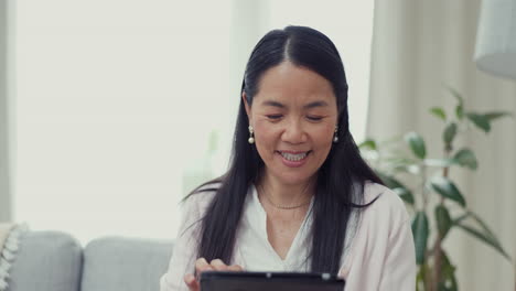 Asian-woman,-tablet-and-living-room-with-a-smile