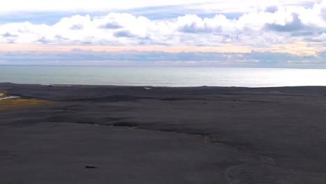Vista-Aérea-Panorámica-De-La-Playa-Volcánica-De-Arena-Negra-Y-El-Océano-Atlántico-Durante-El-Día-Nublado-En-Islandia