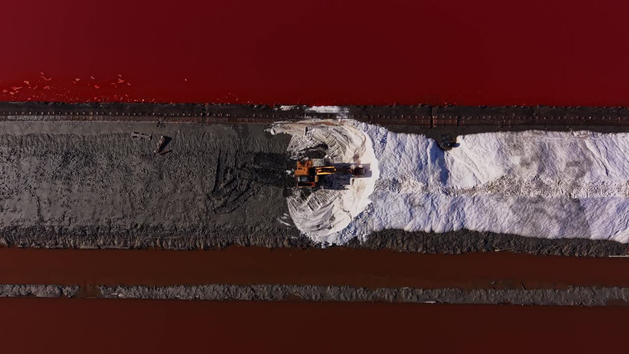 Salt harvesting process in salt pans at sunset in coastal area