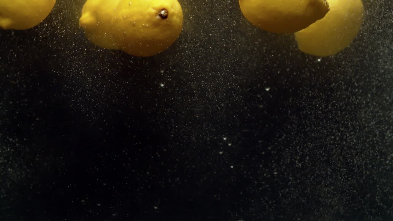 лимоны падают в воду с брызг.