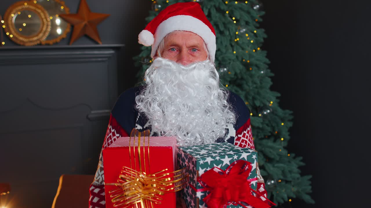 Nonno che imita Babbo Natale mentre consegna una confezione regalo di Natale durante una festa in casa
