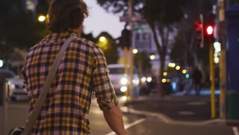 Hombre-Caucásico-Montando-Su-Bicicleta-Y-Cruzando-La-Calle-En-Una-Calle-Por-La-Noche