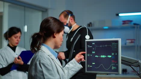 muscular athlete with mask running on cross trainer in medical laboratory