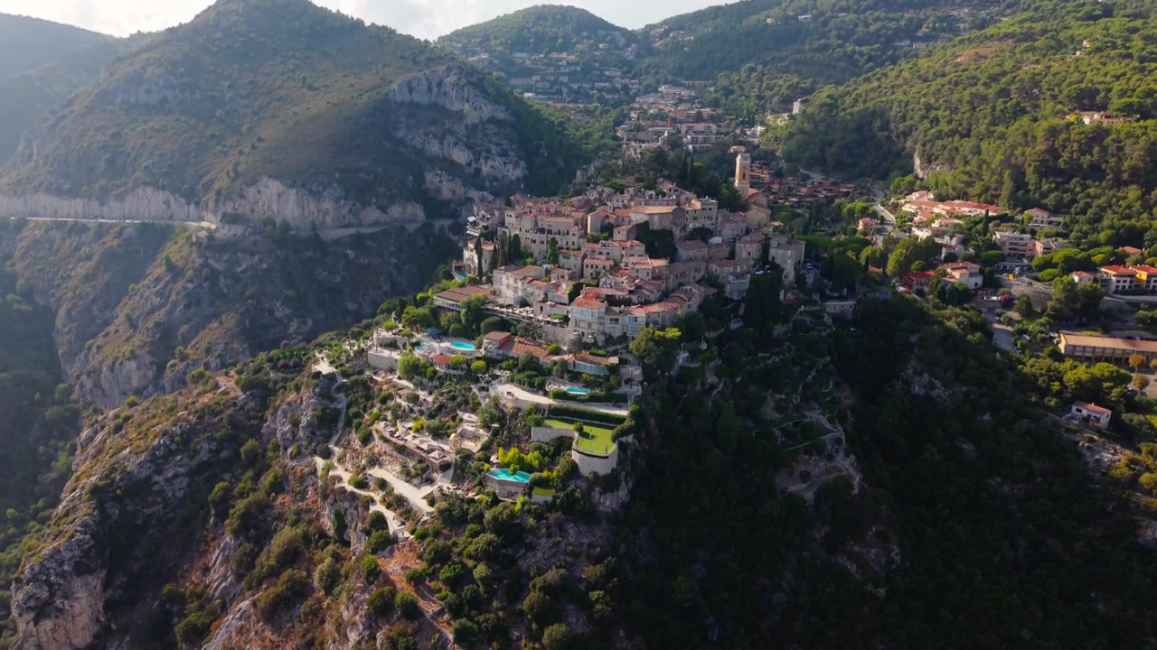 Eze Village, borgo medievale in cima a una collina in Francia, ripreso dall'alto, con case in pietra su un picco roccioso circondato da montagne e foreste, un punto di riferimento della Costa Azzurra.