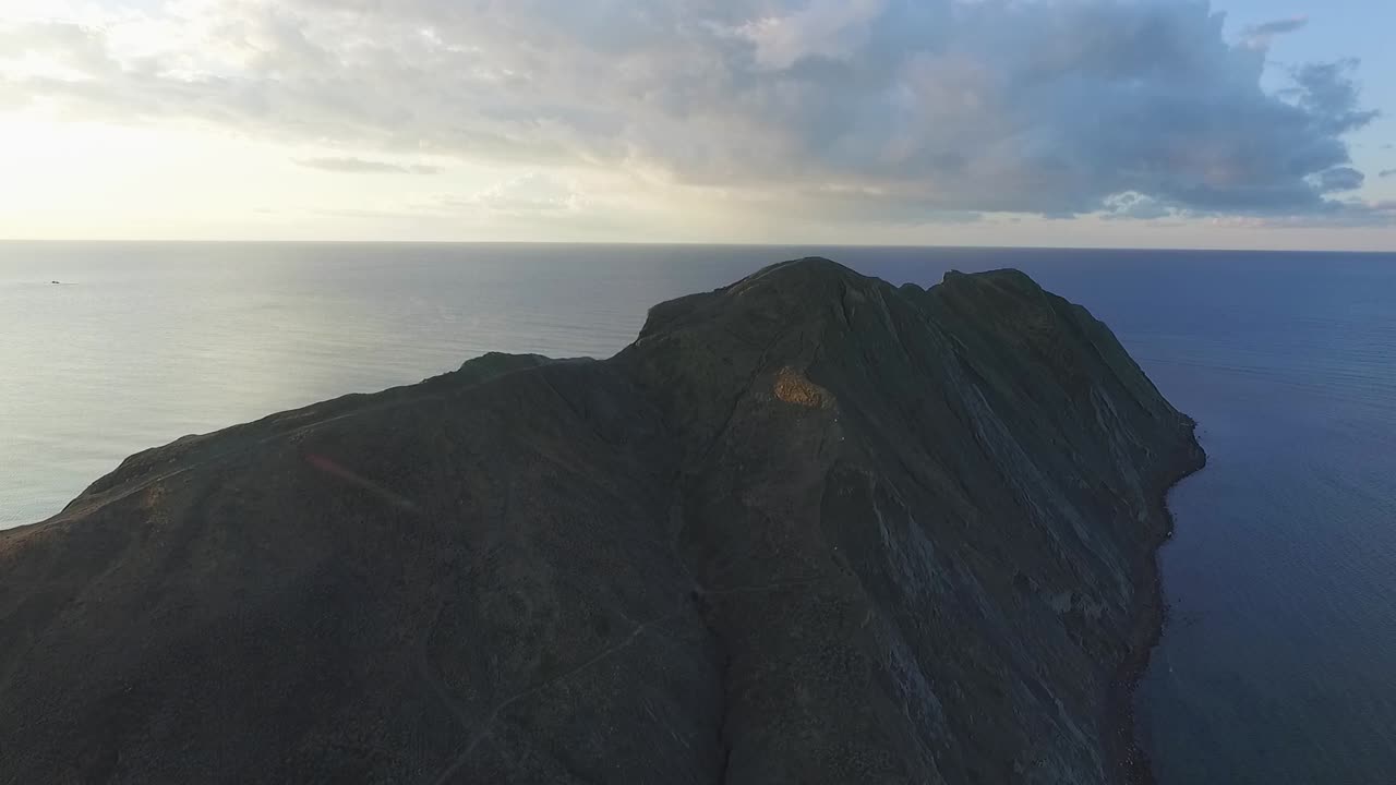 해가 뜨고 해가 지는 해안 산의 공중 사진