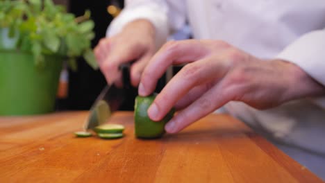 the cook cuts a lime on a wooden board